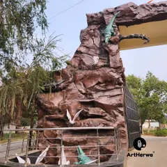 A side view of the Rohtak Zoo gate, highlighting the detailed sculpting of the artificial rockwork and the placement of the crocodile figures.