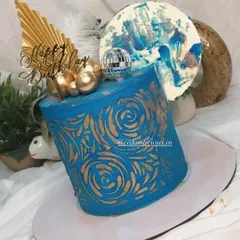 An asymmetrical cake I made for my brother's birthday. This modern design features a bold blue ganache with a gold stenciled pattern, topped with a disco ball, feathers, and an abstract chocolate sail.