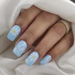 A cute and cheerful design on square nails, with hand-painted daisies and a silver glitter snake accent on a baby blue base.