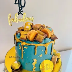 Turning 40 is a milestone that deserves a showstopper. I designed this '40 & Fabulous' cake with a rich teal buttercream, a dramatic gold drip, and topped it with Ferrero Rocher, macarons, and chocolate bars for pure indulgence.