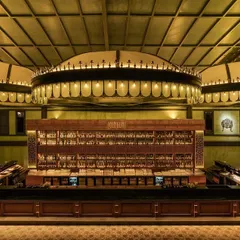 A direct look at the main bar, the centerpiece of the entire project. The three large, illuminated canopies create a sense of scale and drama, drawing the eye and anchoring the space. The back bar is designed for both display and function.