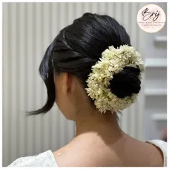A back view of this beautiful and traditional floral bun. It's a timeless hairstyle perfect for any special occasion.