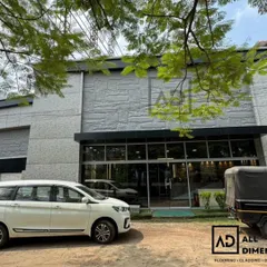 The entire exterior facade of this commercial building is covered in light grey PU stone panels. This gives the building a solid, monumental appearance while being a lightweight and practical cladding solution.