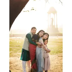A big family hug! This photo captures four family members in a warm embrace during their outdoor session, showcasing their close bond.