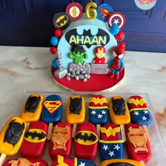 For Ahaan's 6th birthday, we assembled the ultimate superhero team. This cake features iconic heroes like Hulk, Iron Man, and Spider-Man, complete with their symbols and Thor's hammer, paired with matching superhero-themed cakesicles.
