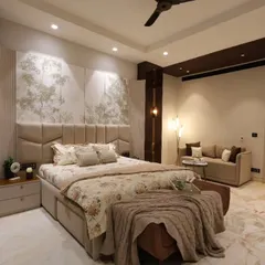 A full view of the master bedroom in Delhi, showcasing the calming tones, balanced textures, and a cozy seating nook that make the space feel warm yet refined.