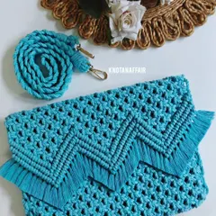 Here is the finished turquoise macrame sling bag, ready to be shipped. It features a detailed V-shaped fringe on the flap and a sturdy, hand-knotted strap with gold-finish clasps. It's a perfect accessory for a beach holiday or a casual day out.