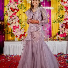 This lavender fish-cut lehenga gown is designed to make a statement. The ruffled dupatta and sequin work create a glamorous look that's perfect for a reception or cocktail event.
