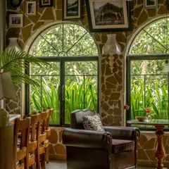 For Echoes Café, we transformed a challenging layout into a series of intimate, soulful corners. This nook, with its rubble-clad walls, arched window, and plush armchair, feels collected over time. It is a space designed not just for a meal, but for a moment of quiet reflection.