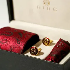 For a bold statement, this crimson red paisley set is an excellent choice. The rich color and intricate pattern on the tie, pocket square, and cufflinks make it a memorable gift.