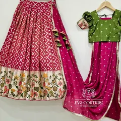 A modern half-saree set with a pink diamond-patterned lehenga featuring a floral border, paired with a green blouse and pink dupatta.