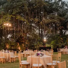 An enchanting outdoor sangeet under a canopy of cascading fairy lights. The minimalist decor with simple table settings allows the magical lighting to be the star of the show.
