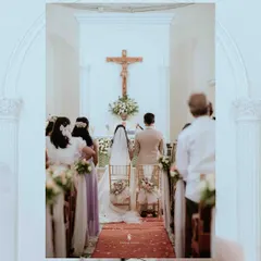 A view from the back of the church aisle as the couple stands before the altar. This perspective captures the solemnity of the ceremony and the support of their loved ones.