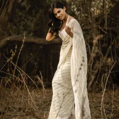 I love using the rustic landscapes around Mumbai to create soft, natural fashion portraits. This image, shot in a wooded area, uses the warm, diffused sunlight to create a gentle, ethereal mood that complements the flowing white saree. It’s a great example of a lifestyle fashion shoot.