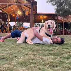 It's all about the bond. This happy Golden Retriever enjoying a cuddle on our spacious lawn captures the relaxed, joyful atmosphere we cultivate at our ranch for both pets and their parents.