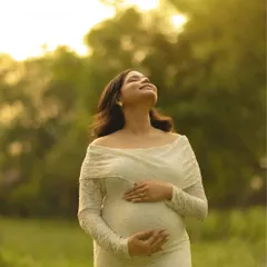 Basking in the golden hour glow. This portrait of the mother-to-be in a white lace dress, looking up at the sun, is a simple yet powerful image of hope and radiance.