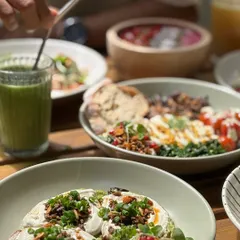 A table full of our nourishing dishes. From colorful bowls to fresh juices, it is all about food that makes you feel good.