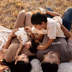 An outdoor family session isn't just about posing; it's about playing. This is a real family enjoying a beautiful day, with their two kids, captured in the warm evening light. These are the candid, joyful memories you'll look back on for years.