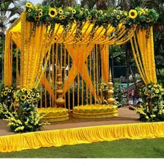 We can create a full mandap for your Haldi ceremony. This outdoor setup features a canopy draped in yellow fabric with sunflower and marigold garlands, creating a beautiful, sun-kissed space for your event.