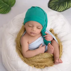 A simple and sweet portrait. The focus here is entirely on the baby, with a soft wrap and a simple knotted hat, showing off their peaceful expression.