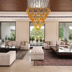 A symmetrical view of the Mehalin Farm drawing room, highlighting the balanced layout and the connection to the outdoors through large windows. The design provides multiple seating areas for large gatherings.