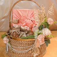 A truly luxurious Rakhi hamper, this wicker basket is overflowing with fabric-wrapped gifts, jars of dry fruits, and is elegantly decorated with faux pearls and dried flowers for a rustic yet opulent feel.