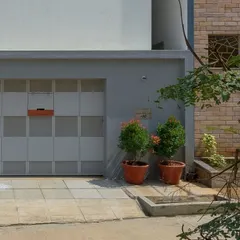 The simple, panelled gate and grey compound wall were intentionally designed to draw the eye upward towards the intricate brickwork of the main facade.