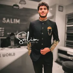 A client wearing a black Jodhpuri suit with gold embroidery on the collar and cuffs, plus a statement brooch. This is a classic, royal look for any grand celebration.