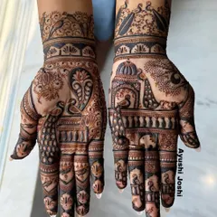 An intricate Indian design for the groom's family, with one hand featuring a majestic elephant and the other a graceful peacock.