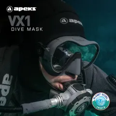 A diver using the Apeks VX1 mask paired with an Apeks regulator. The mask's quick-release buckles and stainless-steel rollers allow for easy adjustments, even when wearing thick dry gloves in cold water.