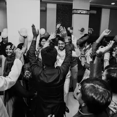 The dance floor is where the energy is. A wide, black and white shot of the Sangeet party in full swing, capturing the collective joy of friends and family.