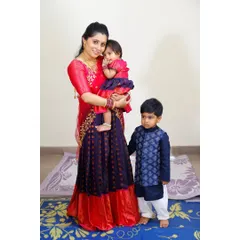 I love creating outfits for the entire family. Here, I designed a matching concept for a mother, daughter, and son using a beautiful red and royal blue silk fabric. The mother's half-saree, daughter's pattu pavadai, and son's kurta create a perfectly coordinated look for family portraits and events.
