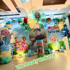 Here is a complete Cocomelon theme setup for a first birthday party at home. This package includes a custom printed backdrop with the child's photo, character cutouts, a full balloon arch, and a light-up marquee number.