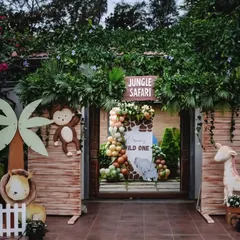 A fantastic jungle safari entrance that makes guests feel like they're stepping into another world. The wooden gate is decorated with a monkey, lion, and giraffe.