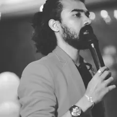 A black and white candid shot of me speaking into the microphone, captured in the middle of hosting an event.