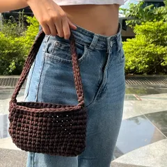 My 'teddy' crochet bag in a rich chocolate brown, modeled to show its size and style. It's made with a thick, sturdy yarn, creating a structured shoulder bag that's perfect for daily use.