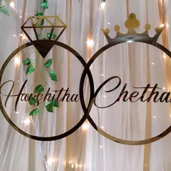 A custom acrylic sign with the couple's names inside interlocking rings, used as a personalized detail on an engagement backdrop.