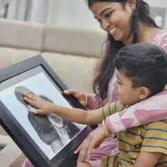 The pure, unfiltered reaction of a child seeing his family in a sketch is priceless. He gently touches the portrait, connecting with the memory I helped bring to life.