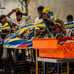 A glimpse into the focused environment of our pit garage. The team works diligently on a kart, making precise adjustments to the chassis and engine between races.