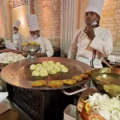 A close-up of my live tawa station, where our chef is skillfully preparing hot and fresh aloo tikkis for guests. This is a classic favorite at any Indian wedding or celebration.