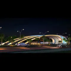 The same entrance gate viewed at night, transformed by integrated lighting. The illumination highlights the gate's dynamic curves, turning it into a landmark that is visible from a distance.