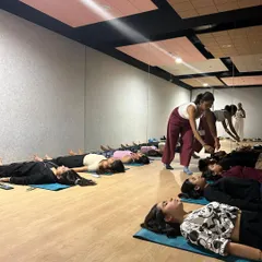 In my group classes, I focus on providing personal attention to help you find the right alignment and deepen your practice safely. Here, I'm assisting a student during a corporate wellness session to ensure they get the most out of their relaxation.