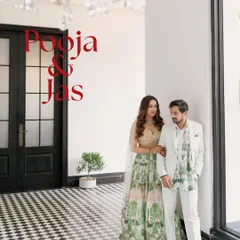 A stylish portrait of a couple, Pooja and Jas, at their Roka ceremony. The modern, checkered floor and classic architecture of the venue provide a sophisticated backdrop for their elegant attire.
