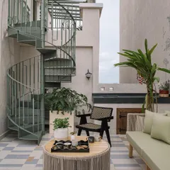 A winding spiral staircase on the outdoor deck connects the two floors of the penthouse. This functional element is also a beautiful design feature, adding to the home's whimsical and verdant character.