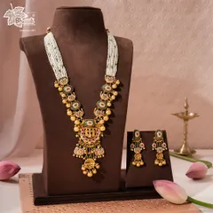 A wider view of the majestic Rajnitya Haar, showcasing its full length and the accompanying earrings. The multi-strand pearl chain adds a layer of softness to the ornate gold pendant, creating a perfectly balanced piece of royal adornment.