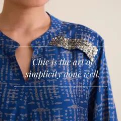Chic is the art of simplicity done well. This image highlights the delicate, sparkling hand-embroidered patch on the shoulder of our blue printed tunic. It’s a small detail that makes a big impact.