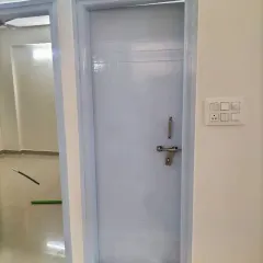 A freshly painted door and frame in a light blue-grey. This solid colour finish is applied evenly for a smooth, professional result that is easy to clean.