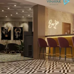 Another view of the modern bar, showing the seating area and the neon 'Bar' sign that adds a playful, trendy vibe. The geometric floor tiles and moody artwork complete this chic entertainment space.