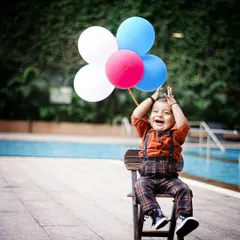 The purest joy is unscripted. This moment of laughter, with balloons ready for fun by the poolside, is exactly what I aim to capture. It's all about real smiles and happy kids.