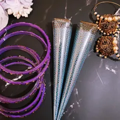 My handmade organic henna cones are available for purchase, perfect for artists and henna lovers. They are pictured here with some festive bangles and earrings, ready for any celebration.